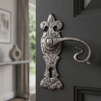 The Alvito Swan Neck Lock Set Natural Textured Pewter.jpg Fitted to a Dark Grey Door in a Home Interior - Digital Illustration