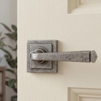 The Ayre Gardens Aged Pewter Unsprung Lever Door Handle on Square Rose On an Open Door Shown Close up - Digital Illustration