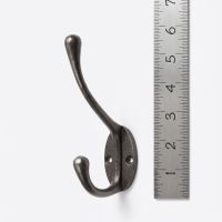 The Blacksmith Antique Iron Two-Prong Coat Hook - 110mm On a White Background  Shown next to a Ruler for Scale - Digital Illustration
