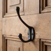 The Blacksmith Antique Iron Two-Prong Coat Hook - 110mm on the Back of a Timber Door - Digital Illustration