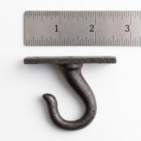 The Blacksmith Heavy Duty Ceiling Chandelier Hook - 65mm on a White Background next to a Steel Ruler for Scale - Digital Illustration