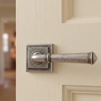 The Bridgerton Rounded Pewter Lever Door Handle on Square Rose Mounted on a Wooden Door in a Country Home - Digital Illustration