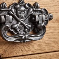 The Cast Antique Iron Skull & Crossbones Drop Handle - Antique Iron Finish Showing a Close up of the Skull Detailing - Digital Illustration