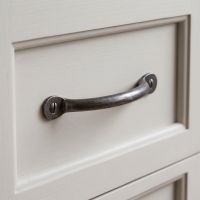 The Cotswold Cast Antique Iron Bow Handle - 100mm Shown on a White Set of Drawers - Digital Illustration