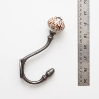 The Cotswold Ceramic Knob Cast Antique Iron Hat & Coat Hook on a White Background next to a Steel Ruler for Scale - Digital Illustration