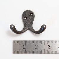 The Cotswold Double Ball-Tip Cast Iron Hook on a White Background next to a Steel Ruler for Scale - Digital Illustration