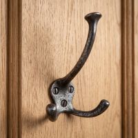 The Cotswold Flared Tip Triple Prong Wall Hook - 125mm Shown Close up Mounted on a Wooden Door - Digital Illustration