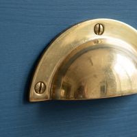 The Cotswold Round Lipped Cup Pull Handle in Brass Shown Close Up Looking at the Attachment Point - Digital Illustration