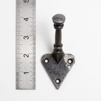 The Craftsman Minimalist Cast Iron Hook - 100mm on a White Background next to a Steel Ruler for Scale - Digital Illustration