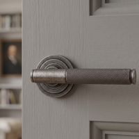 The Edmond Gardens Pewter Textured Lever Door Handle on Art Deco Rose Shown up Close on a Grey Door in a Modern Home - Digital Illustration