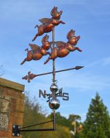 The Flight of Flying Pigs Verdigris Copper Weathervane Mounted in a Wall in a decorative Garden