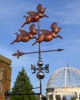 The Flight of Flying Pigs Verdigris Copper Weathervane Sowing the weathervane Mounted on a Wall against a Blue Sky