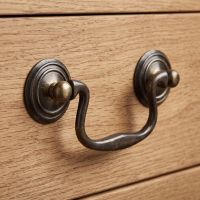 The Georgian Swan Neck Solid Brass Drop Handle - 92mm Shown Close up on a Wooden Drawer - Digital Illustration