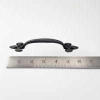 The Gothic Fleur-de-Lis Bow Handle - 157mm on a White Background next to a Steel Ruler for Scale - Digital Illustration