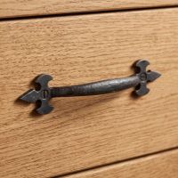 The Gothic Fleur-de-Lis Bow Handle - 157mm Shown on a Traditional Wooden Drawer - Digital Illustration