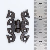The Gothic Serpentine Butterfly Cabinet Hinge - 70mm on a White Background next to a Steel Ruler for Scale - Digital Illustration