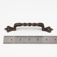 The Gothic Twisted Barley Cast Iron Pull Handle - 145mm on a White Background next to a Steel Ruler for Scale - Digital Illustration