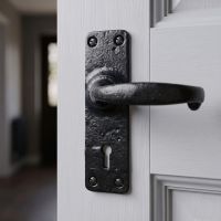The Helmsdrock Foundry Blacksmith Style Lever Handle Shown on a Grey Door Close up in a Modern Home - Digital Illustration