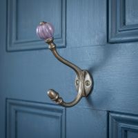 The Ironmonger Acorn Purple Ceramic Coat Hook - 125mm Shown up Close on the Back of a Blue Door - Digital Illustration