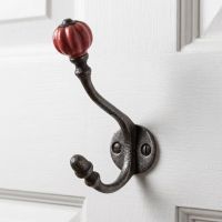 The Ironmonger Acorn Rose Red Ceramic Coat Hook - 125mm Shown Mounted onto a White Coloured Door - Digital Illustration