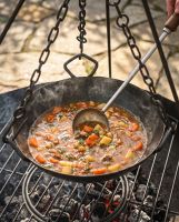 The Kadai Cooking Bowl with Hanging Chains Shown Being Used to Cook a Stew over a Fire Pit - Digital Illustration
