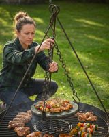 The Kadai Hanging Stone BBQ Griddle Plate With a Lady Shown Attaching the Chains to a Tripod - Digital Illustration