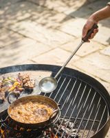 The Kadai Long-Handled Iron Cooking Ladle with Wooden Grip Shown Over the Coals of a Kadai Bowl with a Casserole