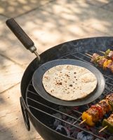 The Kadai Tawa Flat Iron Cooking Pan with Wooden Handle Shown Resting on a Kadai Bowl with Grill with a Roti Cooking on it - Digital Illustration