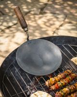 The Kadai Tawa Flat Iron Cooking Pan with Wooden Handle Shown resting on the Grill of a Kadai Bowl being Used for a BBQ - Digital Illustration