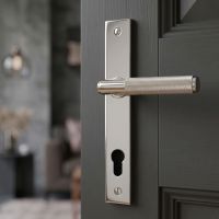 The Knurled Slimline Lever Espagnolette Door Handle Set in Polished Stainless Steel on a Grey Door leading to a Living Room - Digital Illustration
