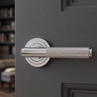 The Knurled Sprung Handle Set on an Art Deco Rose in Polished Stainless Steel Shown Close up on a Charcoal Grey Door - Digital Illustration