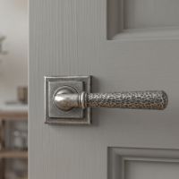 The Landen House Aged Pewter Hammered Unsprung Lever Door Handle on Square Rose on a Light Grey door in a Modern Home - Digital Illustration