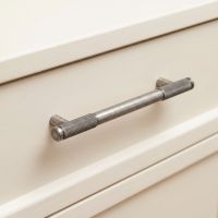 The Medium Half Knurled Cabinet Pull Handle in Pewter on a Cream Set of Drawers in a Kitchen Environment - Digital Illustration