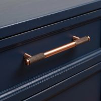 The Medium Half Knurled Cabinet Pull Handle in Polished Bronze Fitted onto a Dark Navy Set of Drawers - Digital Illustration