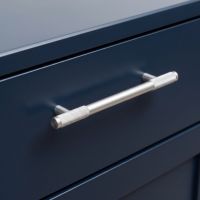The Medium Half Knurled Cabinet Pull Handle in Satin Chrome In a Modern Kitchen on a Blue Set of Drawers - Digital Illustration