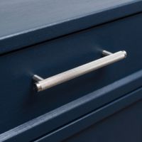 The Medium Knurled Cabinet Pull Handle in Satin Chrome on a Dark Navy Set of Drawers in a Contemporary Home - Digital Illustration