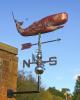 The Moby the Whale Verdigris Copper Weathervane Shown at a Low Angle Mounted on a Wall