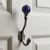 The Regency Navy Ceramic Top Cast Iron Wall Hook Shown Mounted on a White Door - Digital Illustration