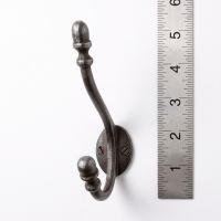 The Regency Oval Backplate Acorn Hook - 130mm on a White Background next to a Steel Ruler for Scale - Digital Illustration