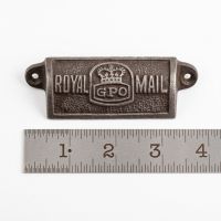 The Royal Mail GPO Cast Antique Iron Cup Pull Handle - 4" on a White Background next to a Steel Ruler for Scale - Digital Illustration