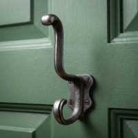 The Schoolhouse Heavy Duty Cast Iron Coat Hook On thre Back of a Wooden Dooor Painted Green - Digital Illustration