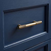 The Small Half Knurled Cabinet Pull Handle in Aged Brass on a Blue Drawer in a Modern Home Interior - Digital Illustration