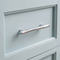 The Small Half Knurled Cabinet Pull Handle in Polished Chrome On a Eggshell Blue Coloured Wooden Drawer - Digital Illustration