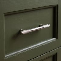 The Small Half Knurled Cabinet Pull Handle in Polished Stainless Steel On an Olive Green Drawer in a Modern Kitchen - Digital Illustration