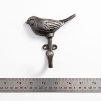 The Songbird Single Cast Iron Coat Hook On a White Background  next to a Ruler for Scale - Digital Illustration