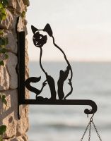 The Steel Siamese Cat Hanging Basket Bracket Shown During a Sunset on a Stone Brick Wall - Digital Illustration