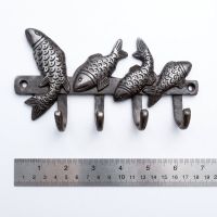 The Swimming Fish 4-Hook Coat Rack in Cast Antique Iron - 170mm On a White Background  with a Rule for Scale - Digital Illustration