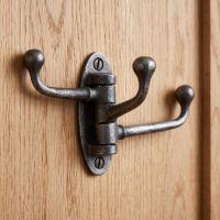 The Swivel Triple Arm Cast Iron Coat Hook 75mm x 100mm Mounted onto the Back of a Wooden Door - Digital Illustration