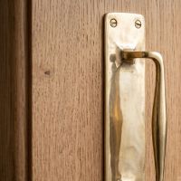 The Taproom Integral Plate Polished Brass Door Pull - 300mm Showing a Close up of the Curved Handle - Digital Illustration