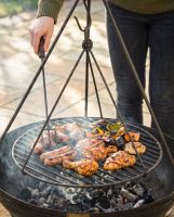 The The Hanging Tripod Swing Grill Used to Grill Food over a lit Kadai Bowl - Digital Illustration